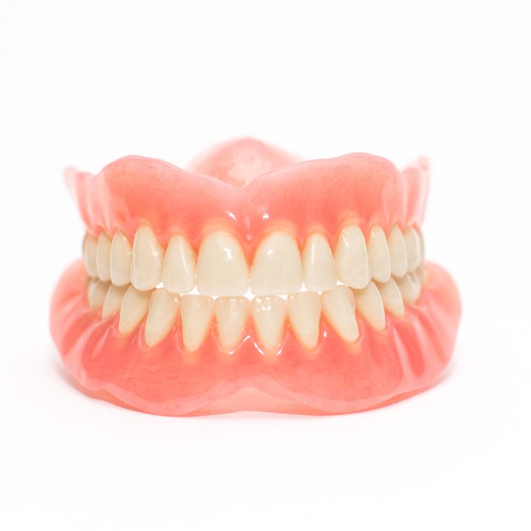 Two acrylic dentures ,white background.